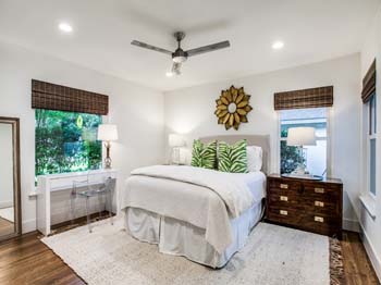 Master bedroom with ceiling fan and refinished floors